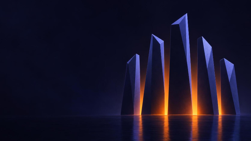 Six tall angular pillars around a warm orange light on a dark reflective floor